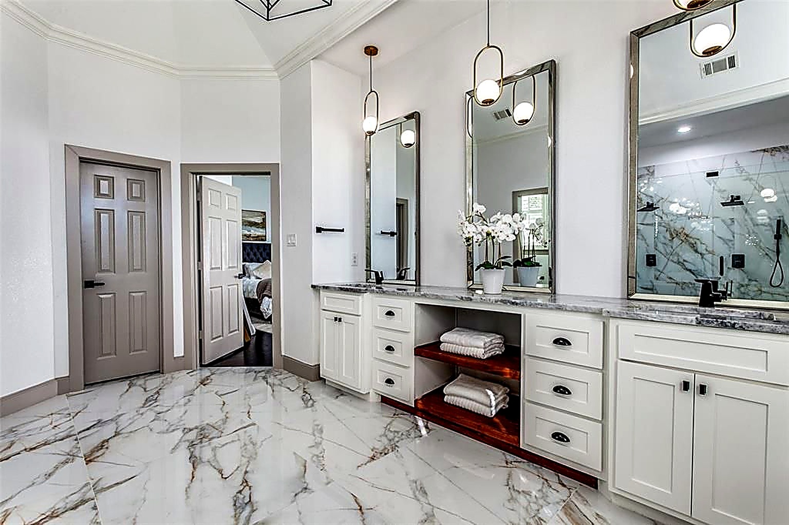 Master bath remodel with custom double vanity, backlit mirrors, and marble flooring